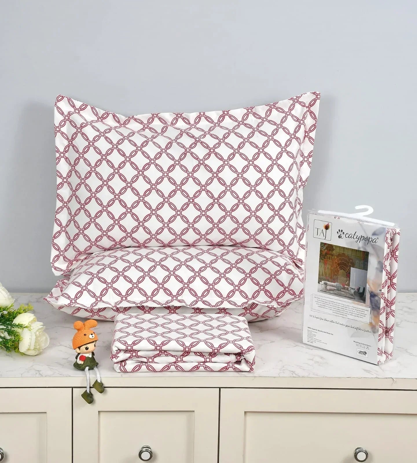 TAJ Collection double bedsheet set with burgundy geometric circle pattern on white background, 100% imported glace cotton fabric, luxury button box packaging with matching pillow covers
towelleo.com