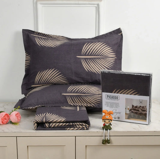 Charcoal grey bedsheet set with gold palm leaf pattern - Picasso collection 3PC cotton bedding set with tropical design by Towelleo.com displayed on white dresser with decorative flowers and packaging
