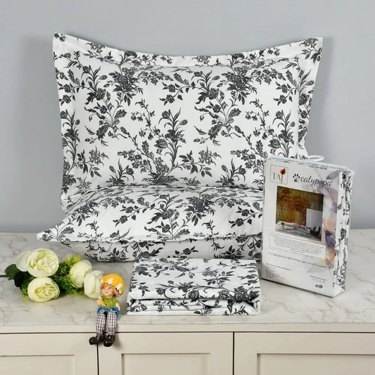 TAJ Collection double bedsheet set with black floral botanical pattern on white background, 100% imported glace cotton fabric, luxury button box packaging with matching pillow covers
towelleo.com