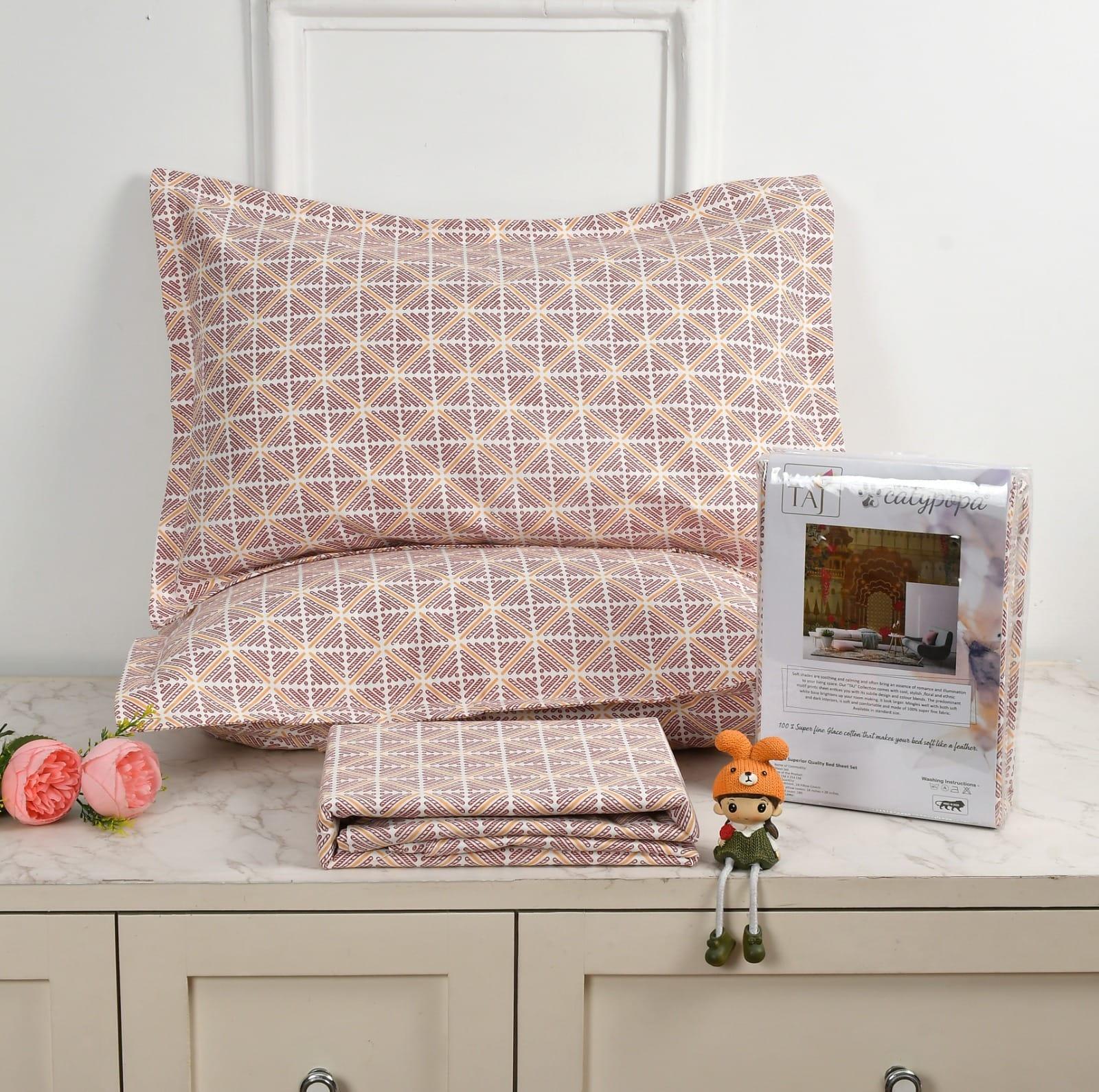 Patterned bedding set with a pillow and folded sheet on a surface, accompanied by a toy and product packaging towelleo.com